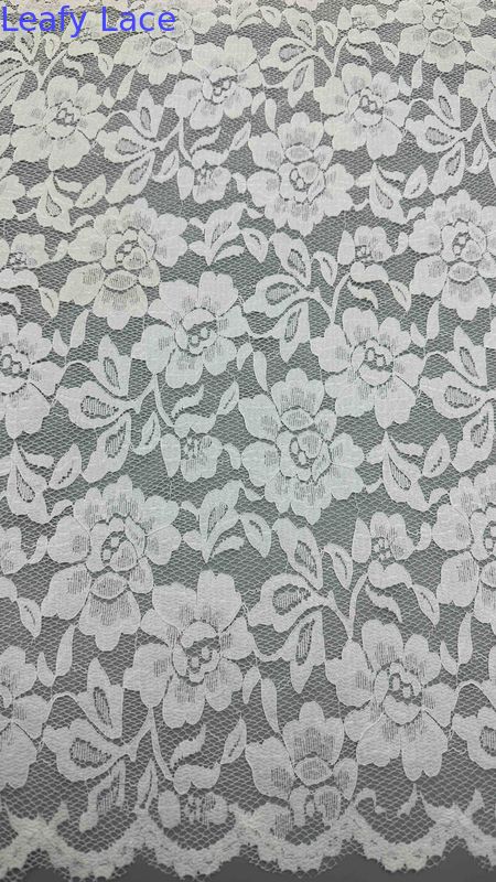 Full Width Stretch Lace Fabric In White, Adorned With Delicate Floral Patterns And Scalloped Edges Luxuriously